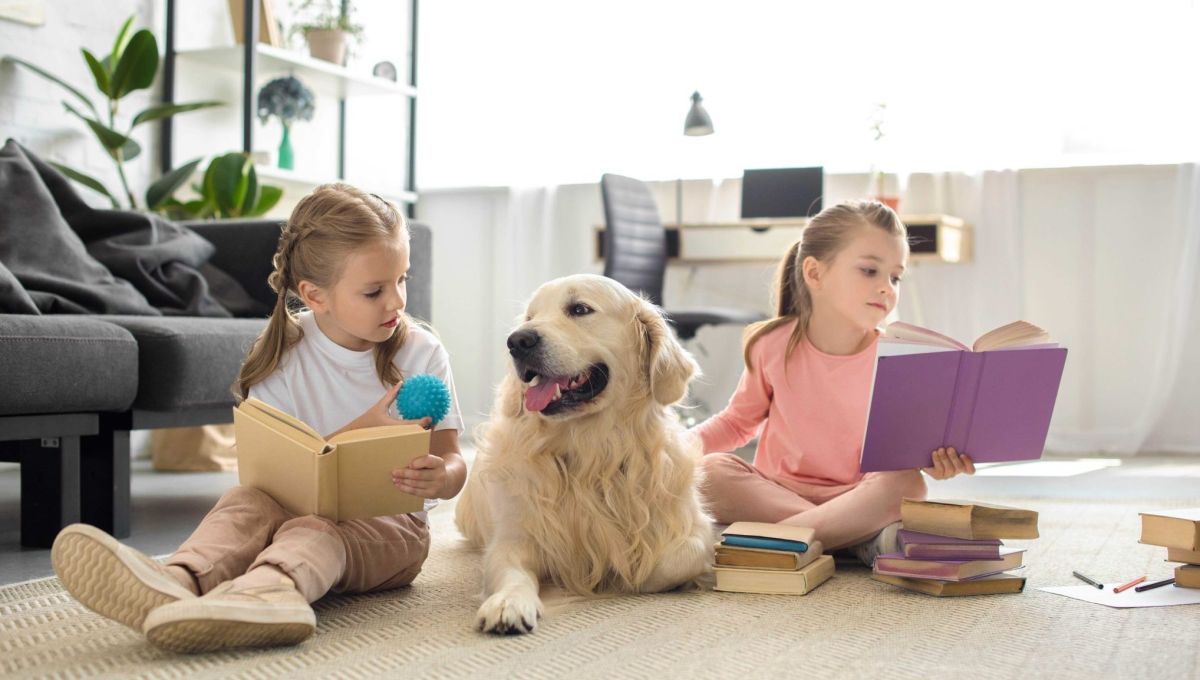 Deux petites filles lisent en présence d'un chien