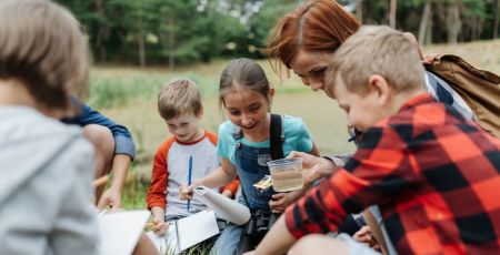 Enfants à l'extérieur entrain d'analyser un pot d'eau