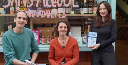 Augustin Laborde, Raphaële Bortolin et Maud Catté sont devant la devanture du Paon Qui Boit, cave sans alcool à Paris. En souriant, ils présentent leur livre " Paris sans alcool friendly ".