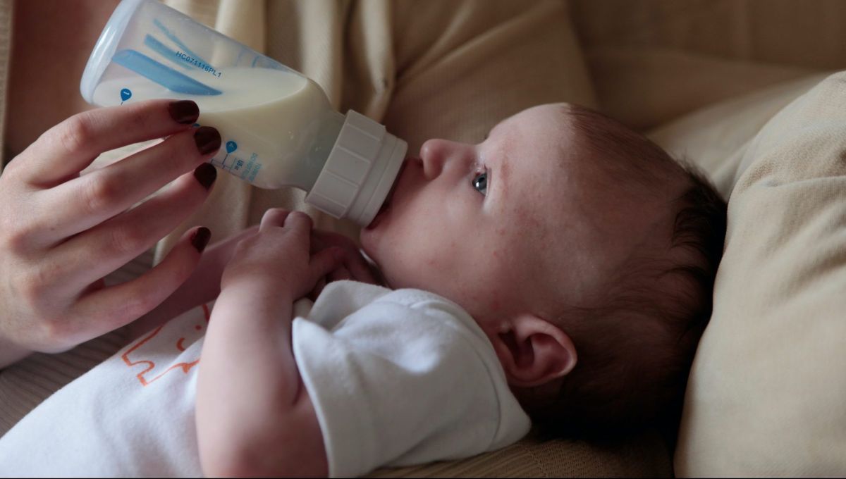 Un bébé boit au biberon du lait