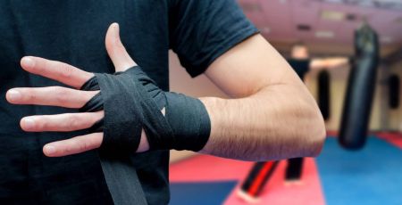 Man putting bandages on hands before marshall arts training in s
