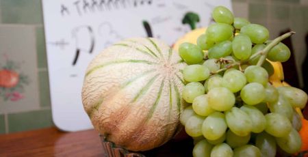 Melon et raisin posés dans un plat sur une table