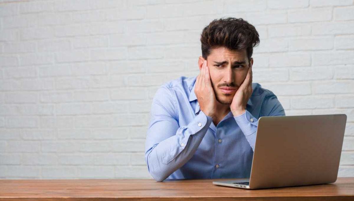 Un homme se bouche les oreilles, importuné par les bruits environnants.