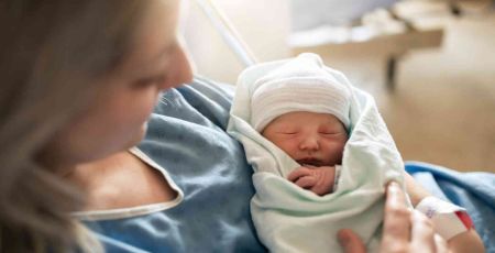 Une mère tient son bébé à la maternité.