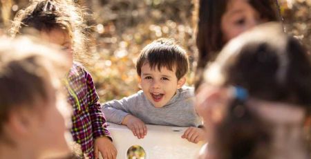 enfant heureux dehors autour d'une table