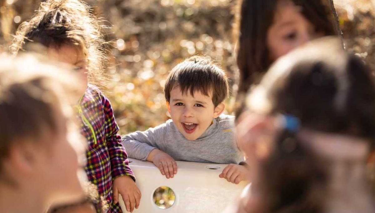 enfant heureux dehors autour d'une table