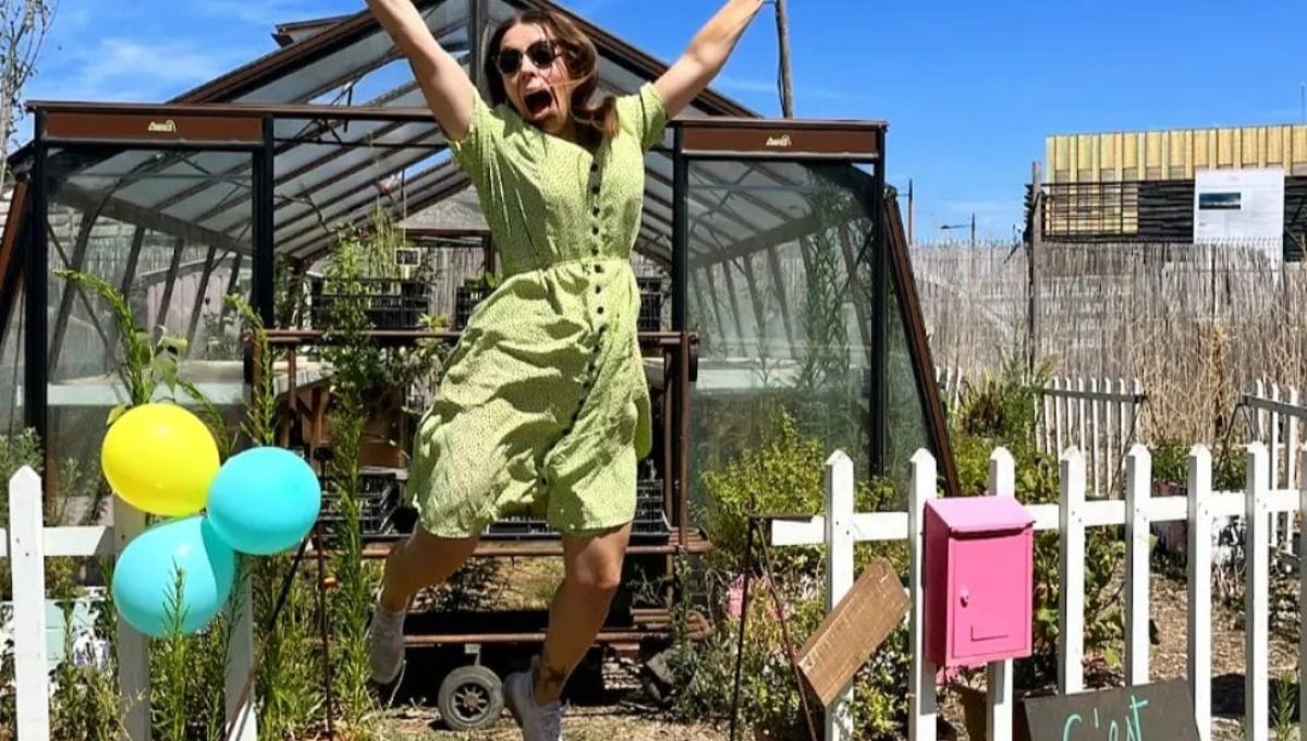 Ophélie Damblé saute de joie devant l'une des serres de sa pépinière installée à Pantin sous un beau ciel bleu azur.