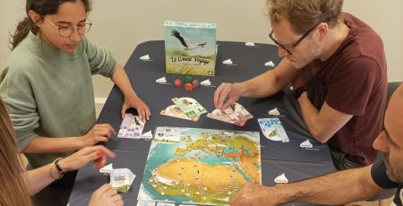 Des personnes joue au jeu de société le Grand Voyage