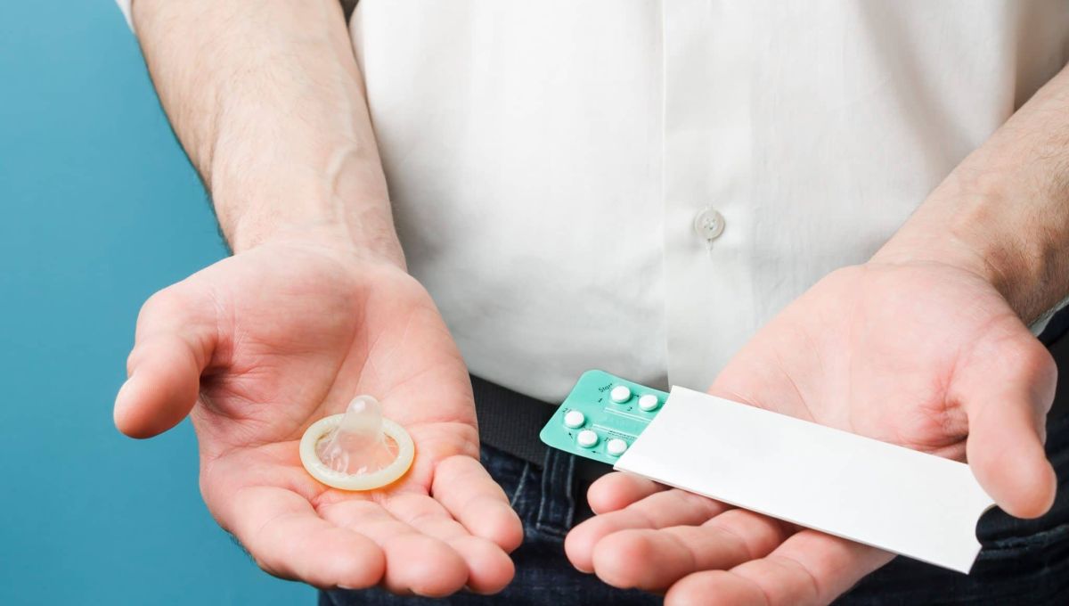 Male contraceptives. Pills and condom in hands of men