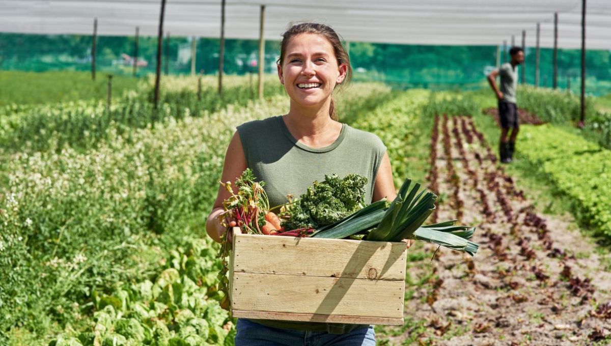 Une femme qui vient de récolter des légumes.