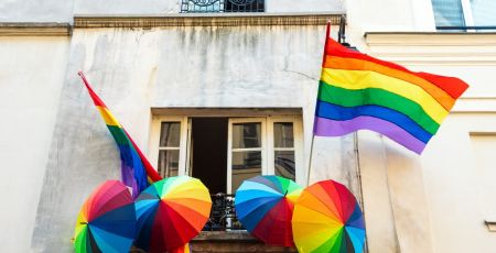 Rainbow LGBT pride flag and umbrellas decoration on a house in  Marais quartier in Paris, France.