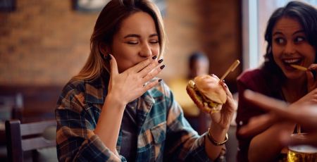 Une femme qui mange un fast food !