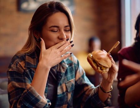 Une femme qui mange un fast food !