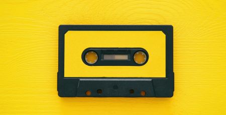 Retro cassette tape over yellow wooden table. top view.