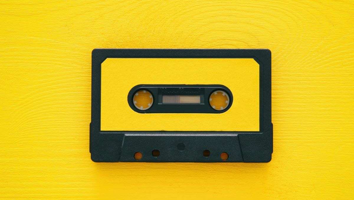 Retro cassette tape over yellow wooden table. top view.