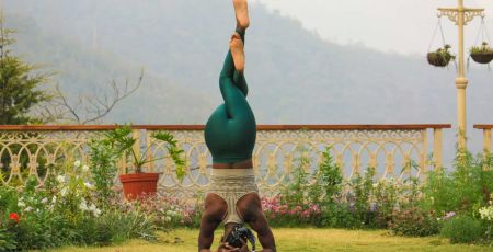 Une dame effectue une posture d'inversion de yoga