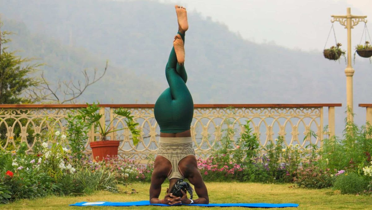 Une dame effectue une posture d'inversion de yoga