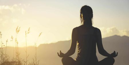 silhouette fitness girl practicing yoga on mountain