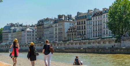 Des personnes marchent le long de la Seine, à Paris