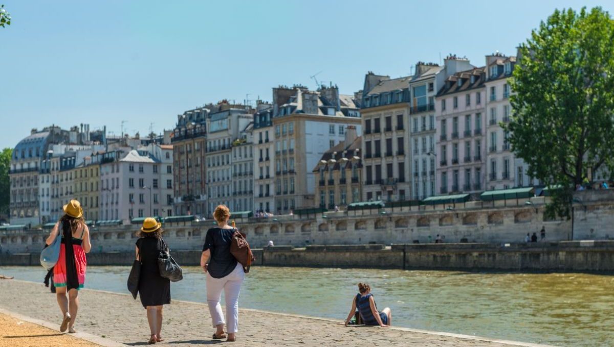 Des personnes marchent le long de la Seine, à Paris