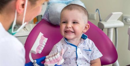 Un petit garçon sourit de toutes ses dents chez le dentiste.