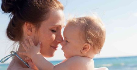 Moment tendresse entre une mère et son bébé à la plage