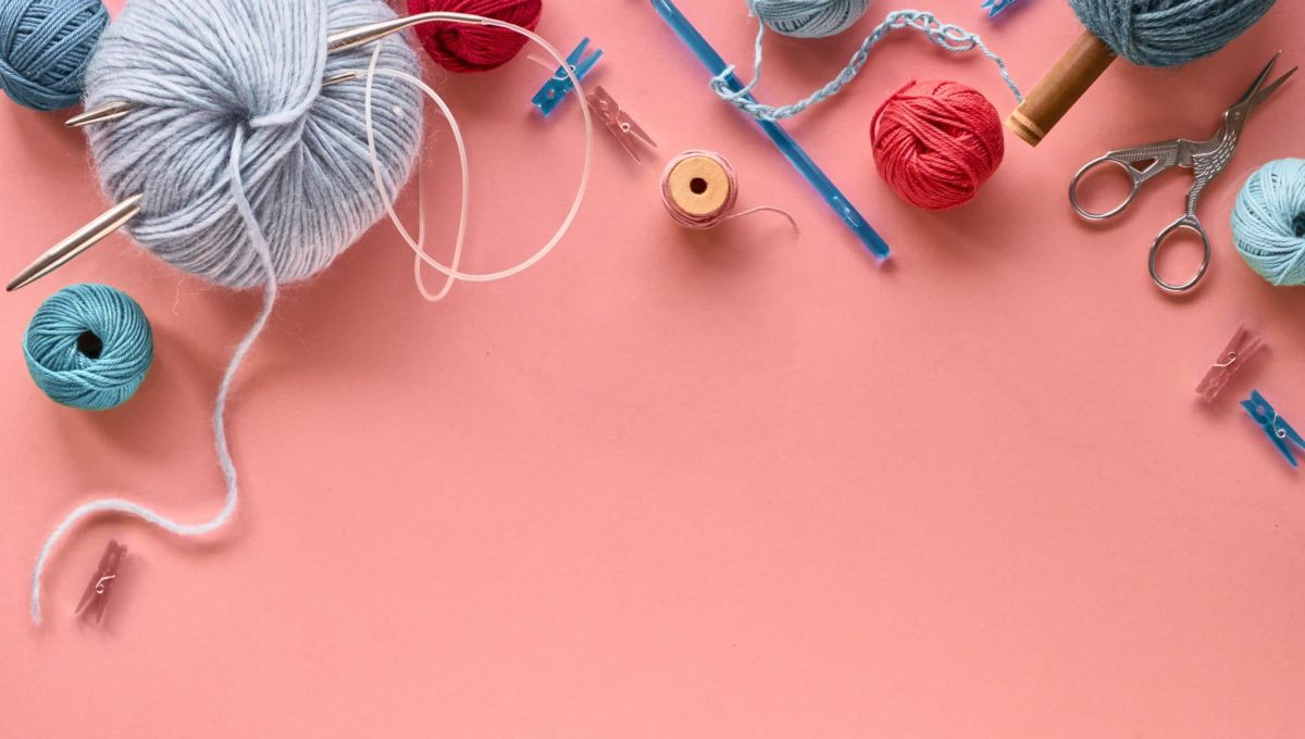 Various wool yarn and knitting needles, creative knitting hobby background with text space