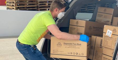 Homme qui aide au chargement des cartons dans une voiture