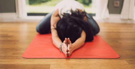 Une femme dans une position de yoga à la maison