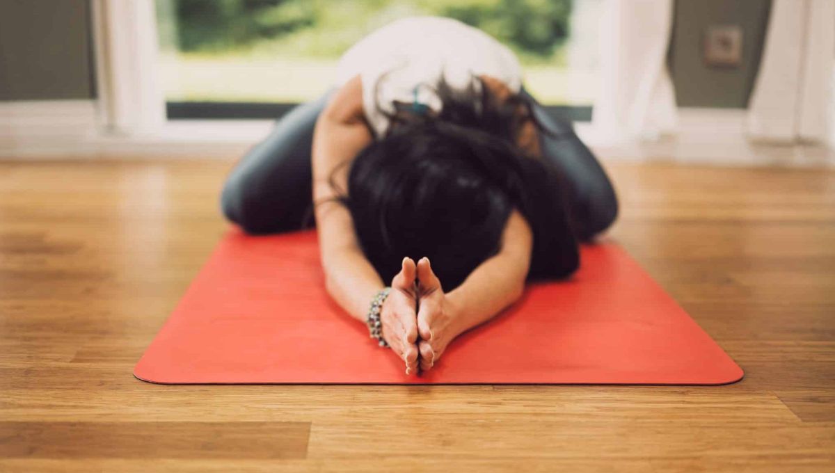 Une femme dans une position de yoga à la maison