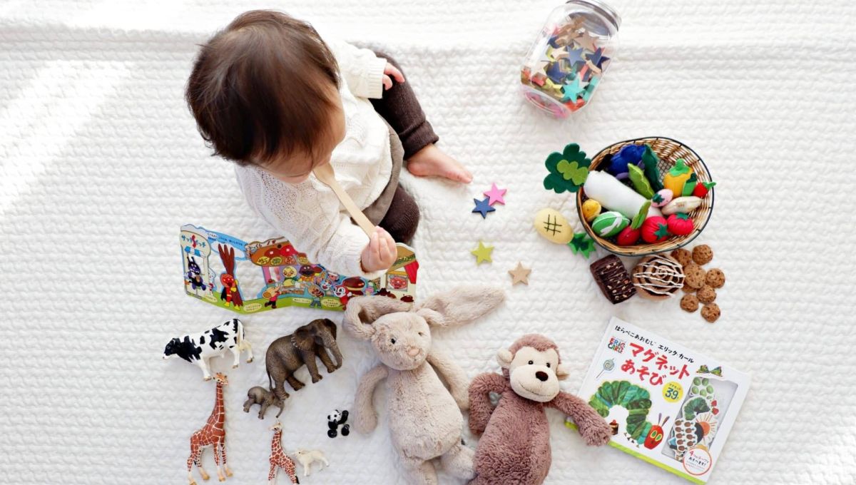 Un jeune enfant entouré de jouet en tout genre.